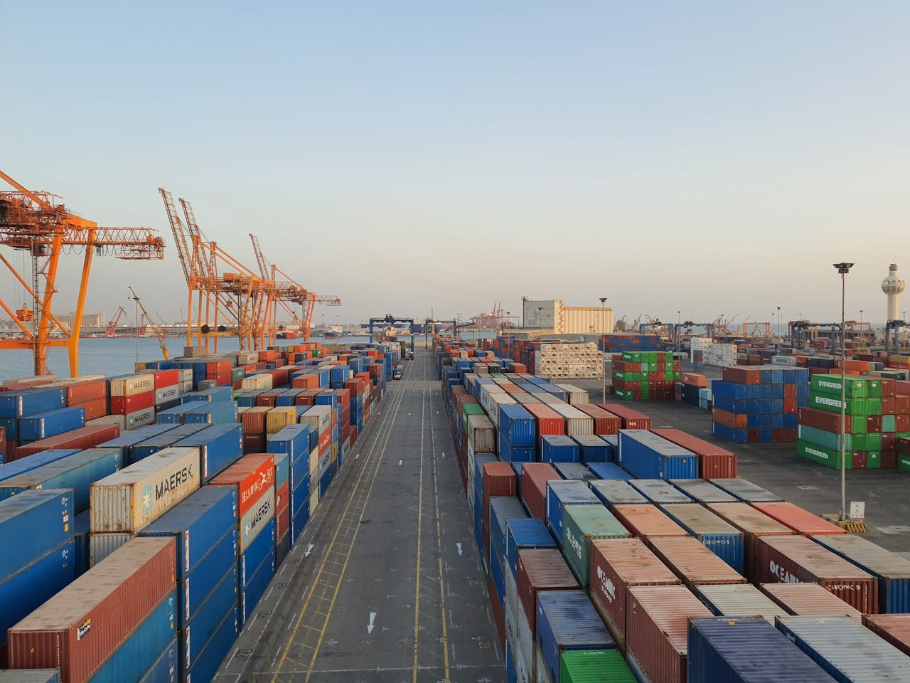 A bustling port scene with colorful cargo containers at sunrise. Ideal for logistics concepts.